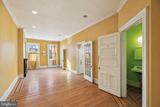 interior space with baseboards, recessed lighting, light wood-style flooring, and crown molding