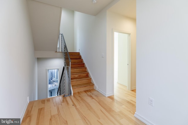 staircase featuring baseboards and wood finished floors