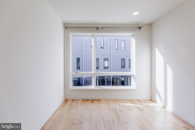 spare room with light wood finished floors and baseboards