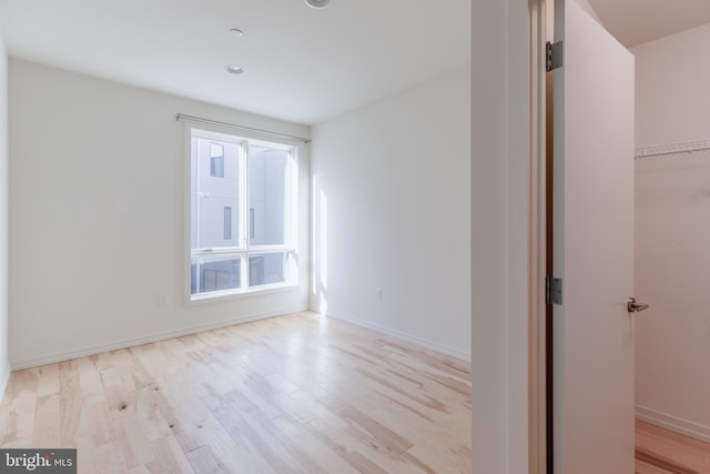 unfurnished room featuring light wood-style flooring and baseboards