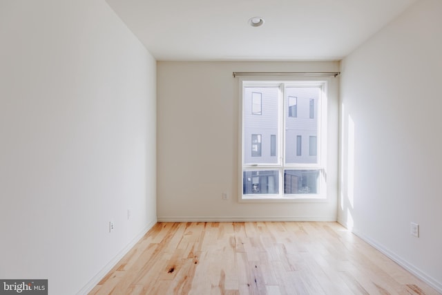 spare room featuring light wood-type flooring and baseboards