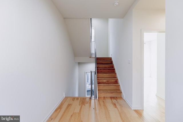 stairway featuring wood finished floors and baseboards