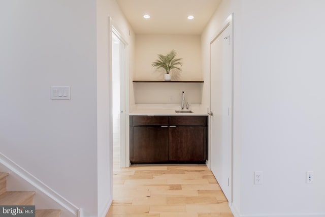 bar with recessed lighting, a sink, stairway, light wood-type flooring, and wet bar