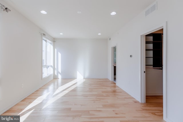 empty room featuring light wood-type flooring, visible vents, and recessed lighting