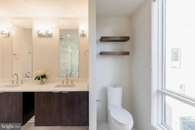 bathroom with double vanity, a sink, toilet, and a shower stall