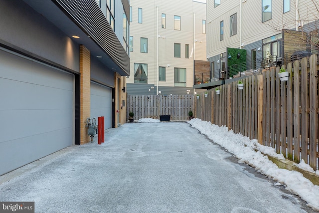 exterior space featuring a garage, driveway, and fence