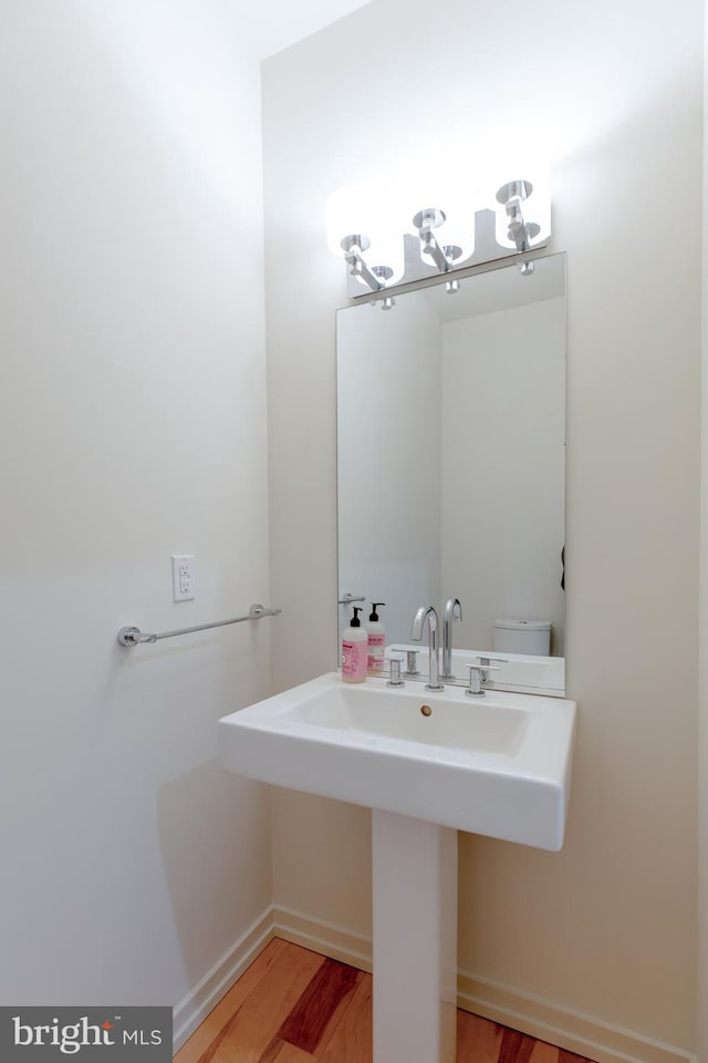 half bath featuring toilet and wood finished floors