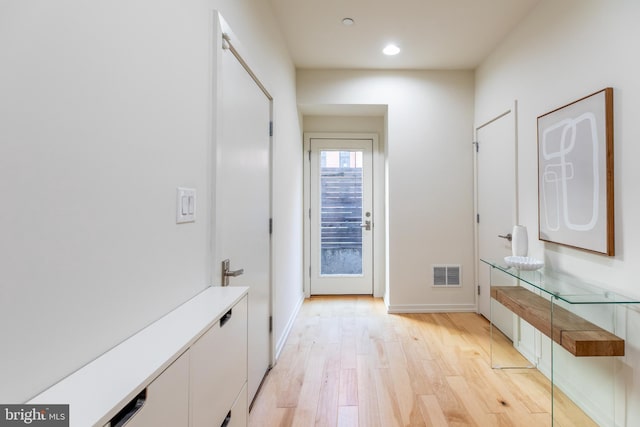 interior space featuring recessed lighting, baseboards, visible vents, and light wood finished floors