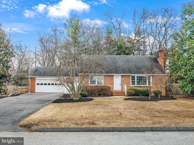 view of front of house with brick siding, driveway, an attached garage, and fence