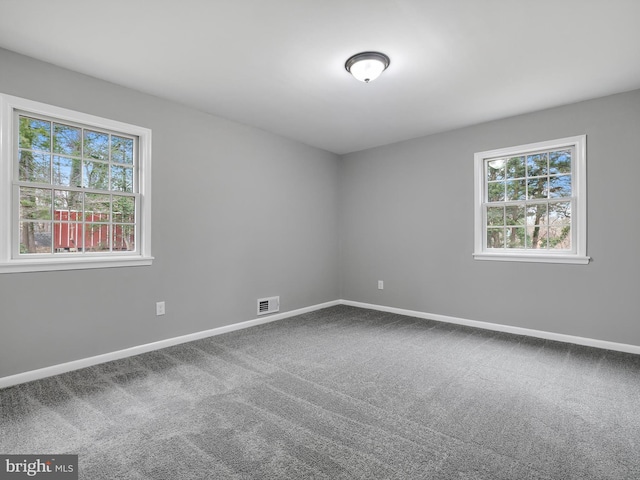 carpeted spare room with visible vents and baseboards