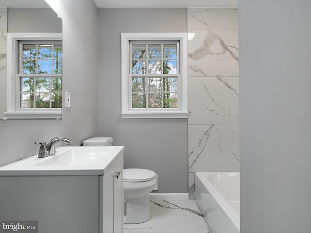 full bathroom with toilet, marble finish floor, a wealth of natural light, and vanity