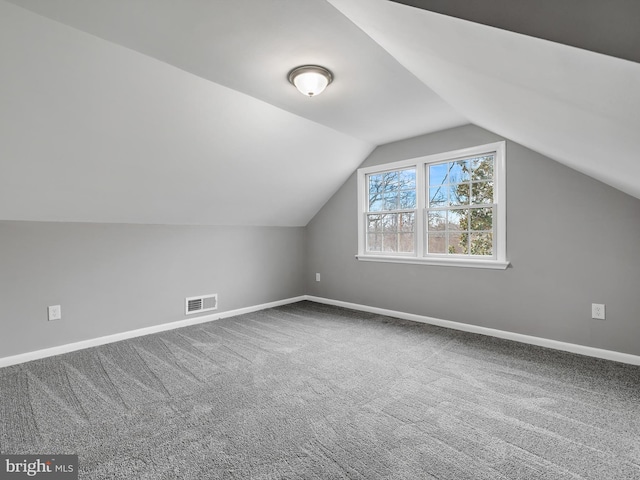 bonus room featuring carpet floors, visible vents, baseboards, and vaulted ceiling