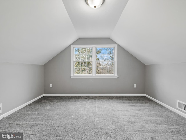 bonus room featuring lofted ceiling, visible vents, baseboards, and carpet flooring