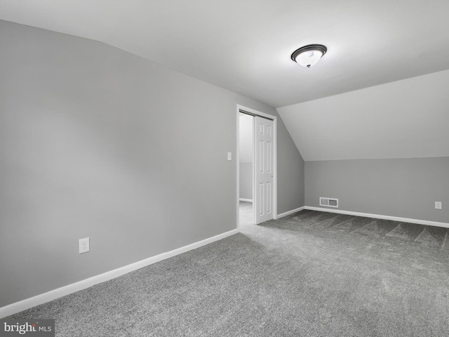 bonus room featuring carpet floors, visible vents, vaulted ceiling, and baseboards