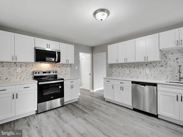 kitchen with appliances with stainless steel finishes, light countertops, and white cabinetry