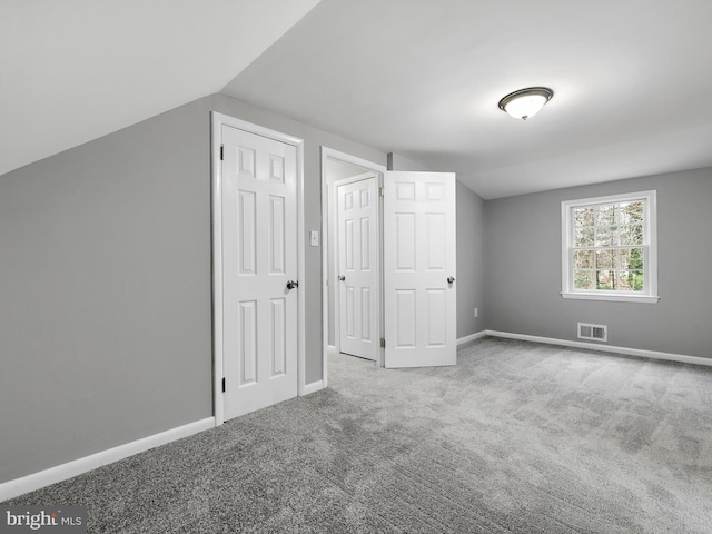 bonus room with vaulted ceiling, light carpet, visible vents, and baseboards