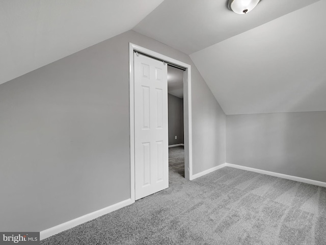 additional living space featuring carpet, lofted ceiling, and baseboards