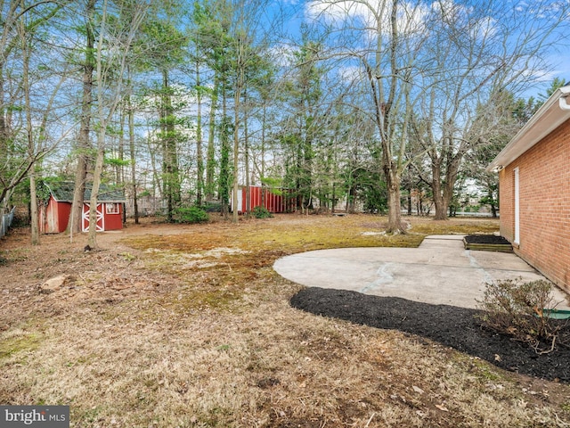 view of yard featuring an outbuilding, a patio, and a shed