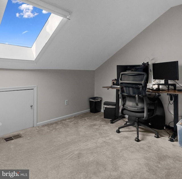 office space with carpet floors, lofted ceiling with skylight, and visible vents