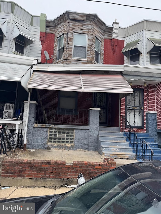 multi unit property with covered porch and brick siding