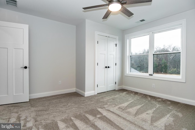 unfurnished bedroom with baseboards, visible vents, and light colored carpet