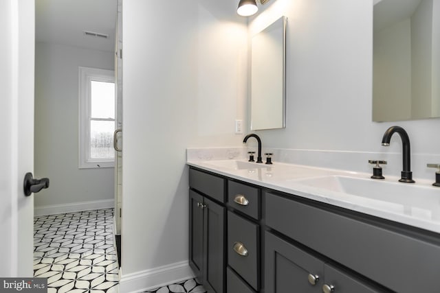 bathroom with a sink, visible vents, and baseboards