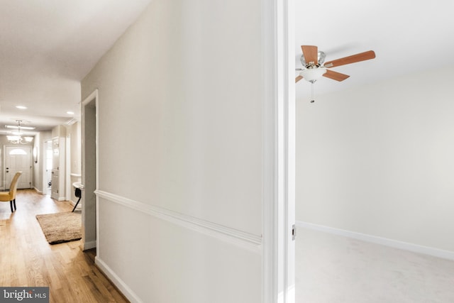 corridor featuring baseboards and wood finished floors