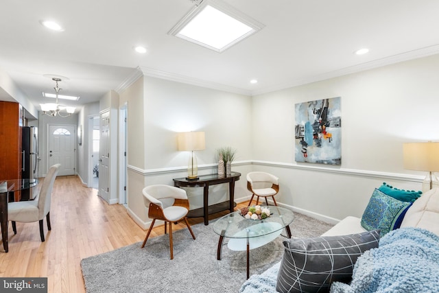 living area featuring baseboards, light wood-style flooring, crown molding, a chandelier, and recessed lighting