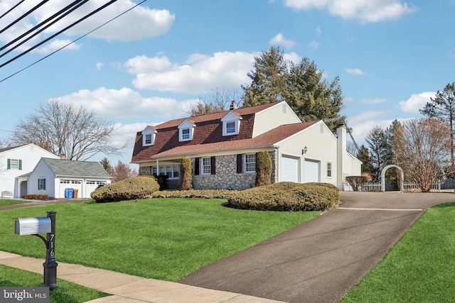 view of front of house featuring aphalt driveway, a chimney, an attached garage, a front yard, and stone siding