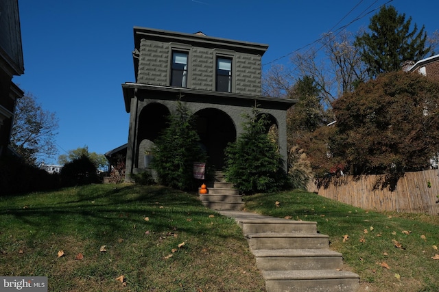 victorian home featuring a front yard and fence