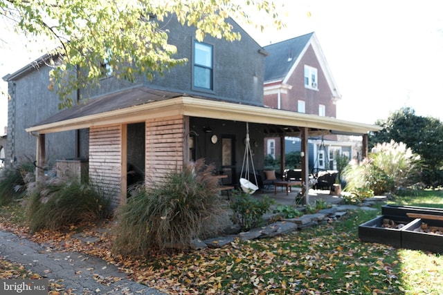 rear view of property featuring a garden