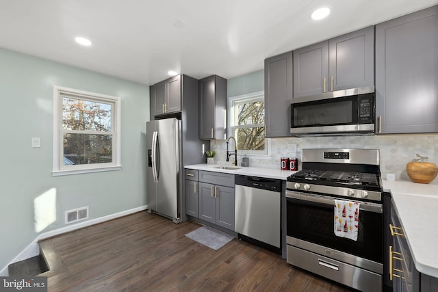 kitchen with light countertops, visible vents, gray cabinetry, appliances with stainless steel finishes, and a sink