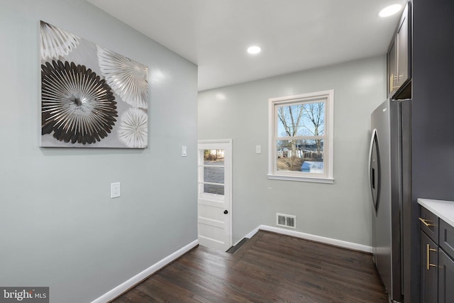 kitchen with visible vents, baseboards, dark wood finished floors, freestanding refrigerator, and recessed lighting