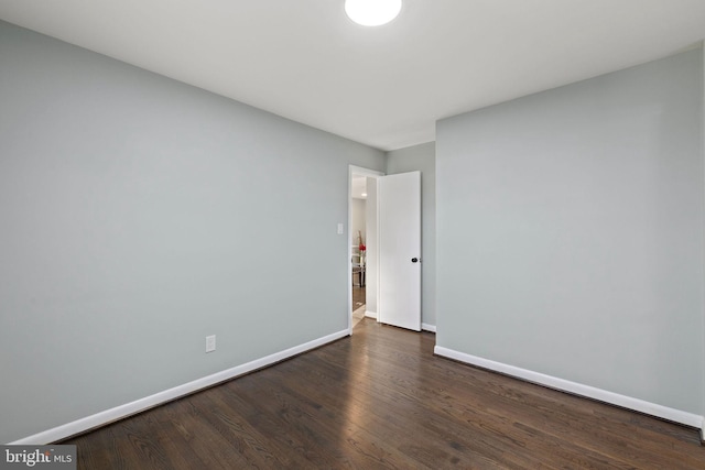 empty room with baseboards and wood finished floors