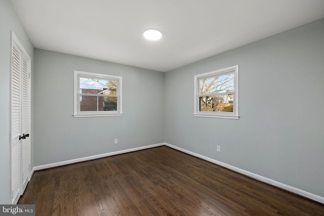 unfurnished bedroom featuring a closet, baseboards, and wood finished floors