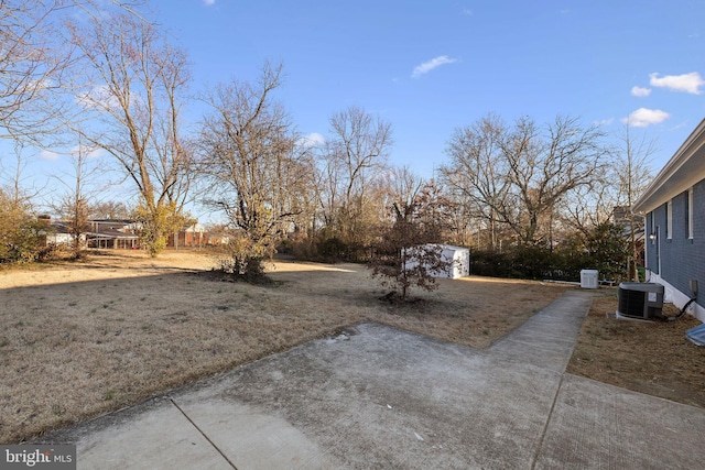 view of yard with an outbuilding, a shed, and central air condition unit