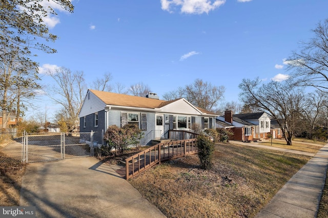 view of front of house featuring brick siding, a chimney, fence, and a gate