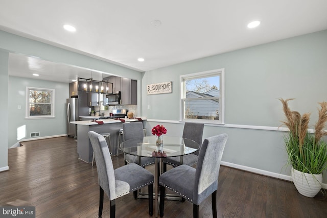 dining area featuring baseboards, dark wood-style flooring, and a healthy amount of sunlight