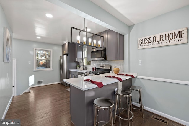 kitchen with tasteful backsplash, visible vents, dark wood finished floors, appliances with stainless steel finishes, and light countertops