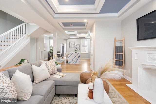 living room featuring ornamental molding, stairway, light wood-type flooring, and baseboards