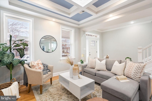 living room featuring light wood-style flooring, coffered ceiling, visible vents, baseboards, and crown molding