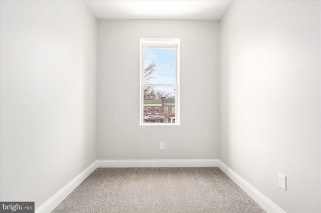 carpeted spare room featuring baseboards