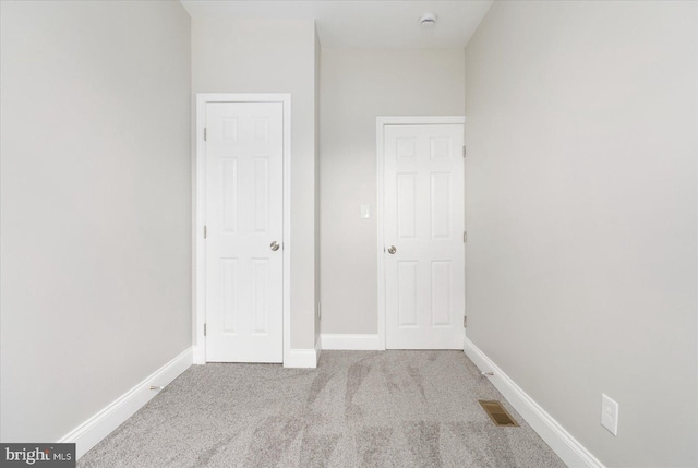 unfurnished bedroom featuring carpet flooring, visible vents, and baseboards