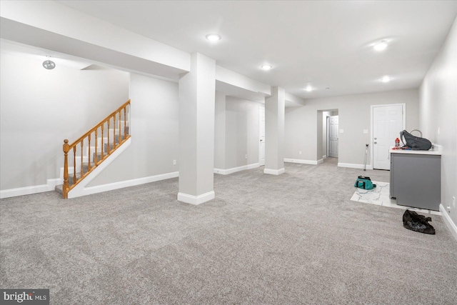 finished below grade area with stairs, carpet floors, recessed lighting, and baseboards