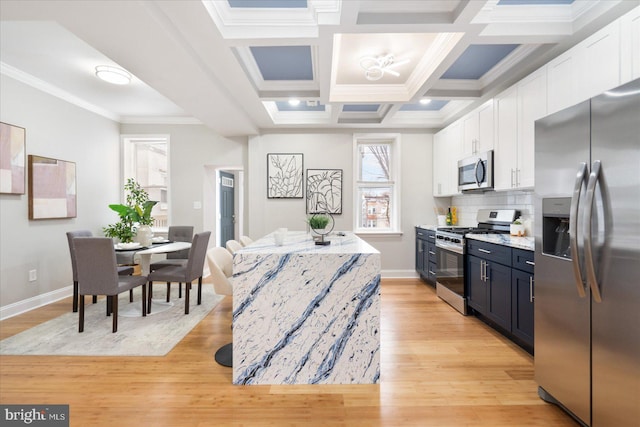 kitchen featuring light wood-style floors, white cabinetry, stainless steel appliances, and decorative backsplash