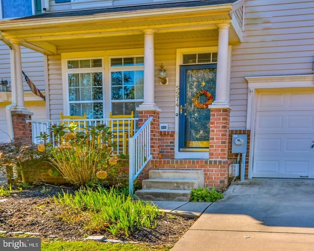 doorway to property featuring a porch and brick siding