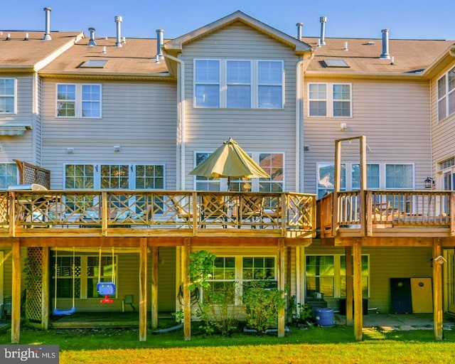 rear view of house with a lawn and a wooden deck