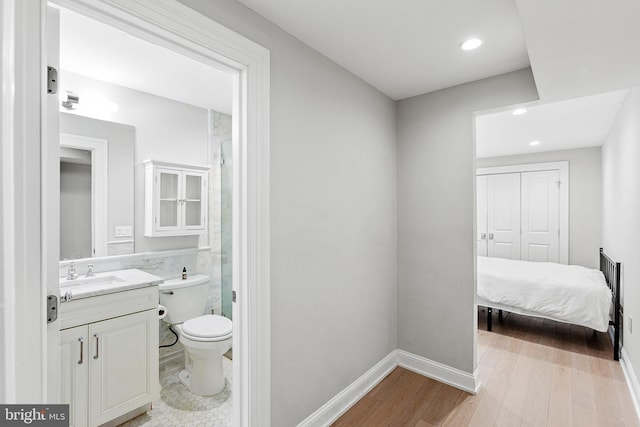 full bathroom with toilet, vanity, wood finished floors, and a shower with shower door