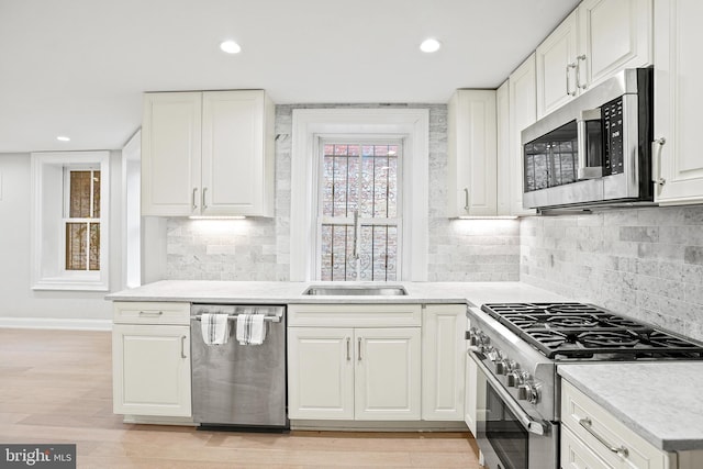 kitchen featuring light wood-type flooring, appliances with stainless steel finishes, and white cabinets