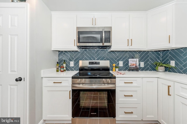 kitchen with appliances with stainless steel finishes, light countertops, backsplash, and white cabinetry